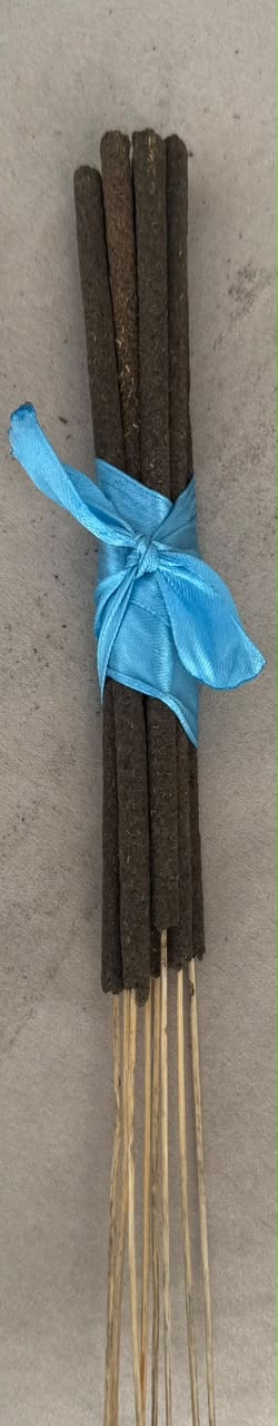 Bundle of finished dark Agarwood incense sticks tied with a blue ribbon