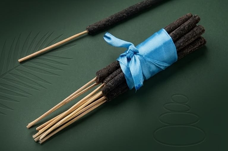 Bundle of dark Majegau incense sticks tied with a blue ribbon